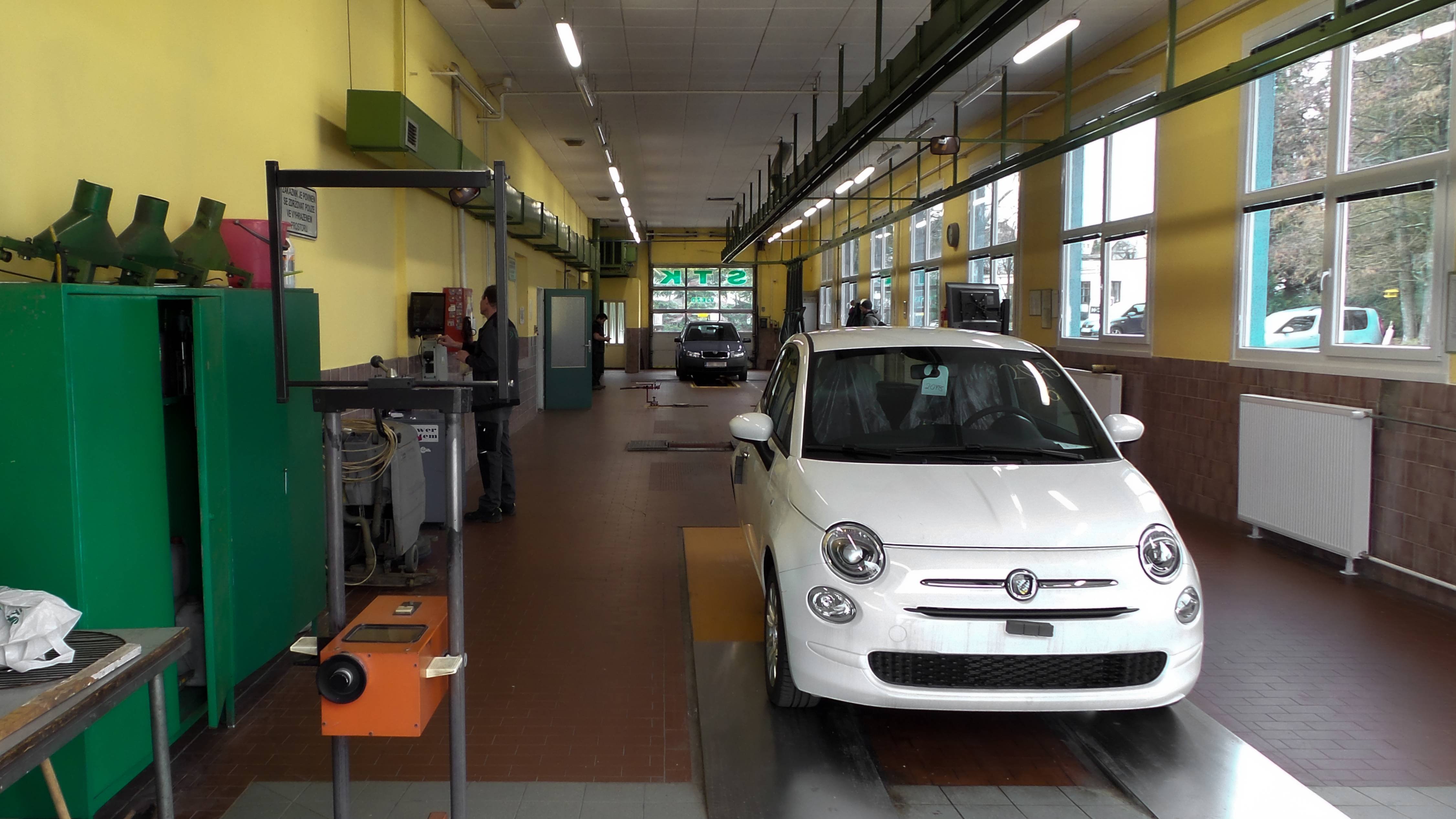 Pohled na pracovní linku STK od výjezdu s bílým autem v záběru
